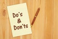 DoÃ¢â¬â¢s and DonÃ¢â¬â¢ts message on a yellow legal lined notepad paper